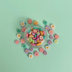 Miniature Resin Flowers (10 pcs) on the aqua coloured background.
