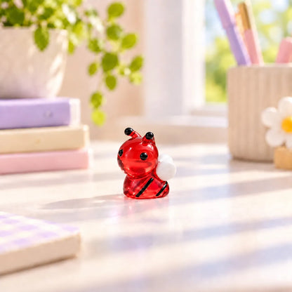 Miniature Glow Bee Assorted (1pc) displayed on a desk near a window with decorative items