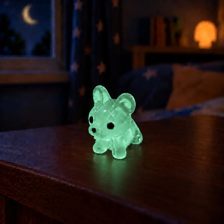 Miniature Glow Mini Dogs Assorted (1pc) glowing on a wooden table in a dimly lit room