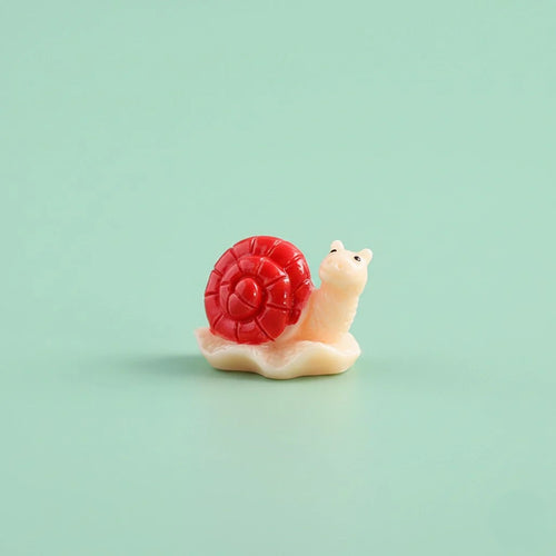 Miniature Snails for Fairy Gardens Assorted on a light pastel green background.