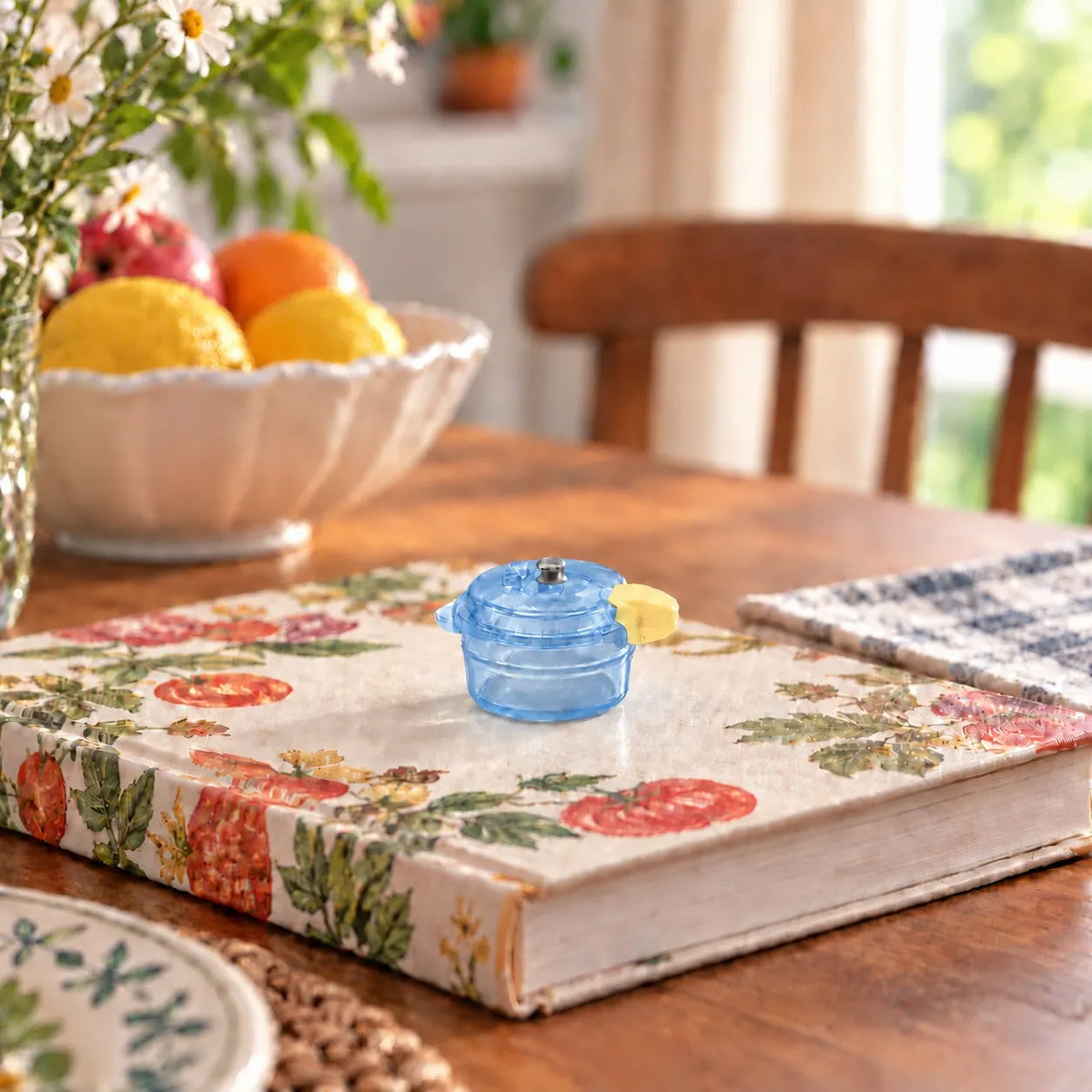Miniature Glow Mini Cooker Assorted (1pc) displayed on a table with decorative items and a fruit bowl
