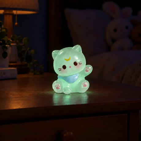 Miniature Glow Mini Bear Assorted (1pc) glowing on a wooden table in a dimly lit room