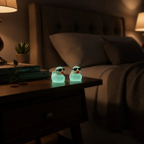 Miniature Glow Mini Duck Assorted (1pc) glowing on a bedside table in a dimly lit room