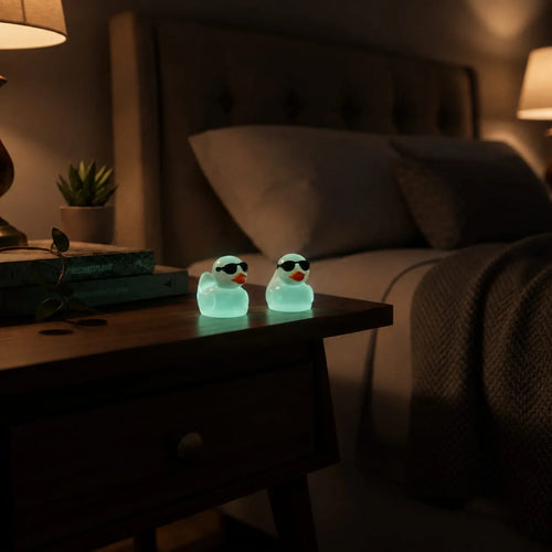 Miniature Glow Mini Duck Assorted (1pc) glowing on a bedside table in a dimly lit room