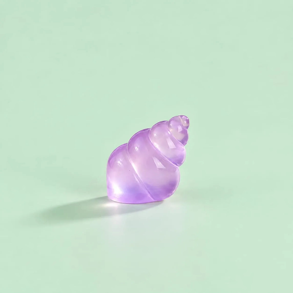 Miniature Glow Conch Shell Assorted (1pc) displayed on a mint green background