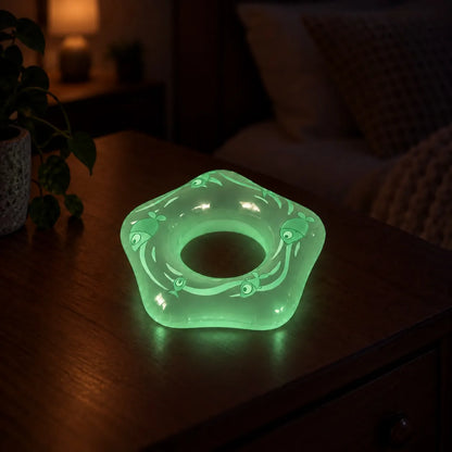 Miniature Glow Floating Swimming Ring Assorted (1pc) glowing on a wooden table in a dimly lit room