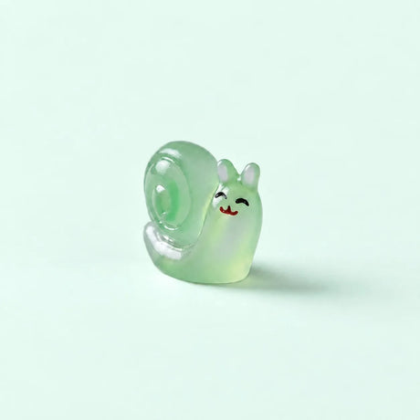 Miniature Glow Snail Assorted (1pc) displayed on a mint green background